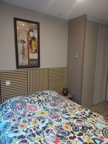 a bedroom with a bed with a colorful comforter at La Marceline Gîte avec piscine près de Lascaux IV in Aubas