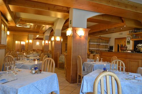 una sala da pranzo con tavoli e sedie con panna blu di Hotel Giardino a Bormio