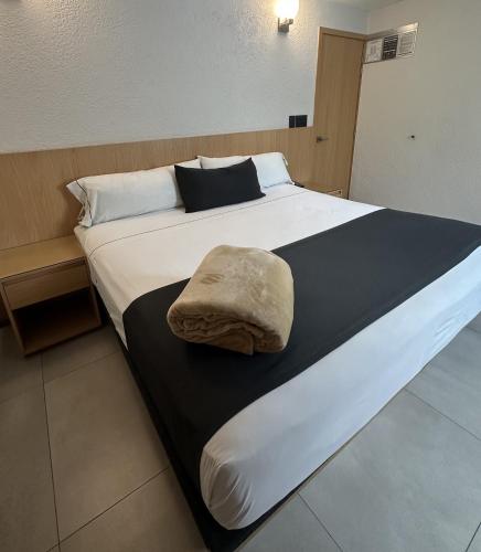 a large bed with a pillow on top of it at Hotel Emperador centro Guadalajara y Remodelado in Guadalajara