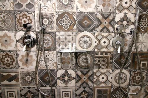 a bathroom with a wall covered in decorative tiles at Casale Sienti'n Può in Norcia