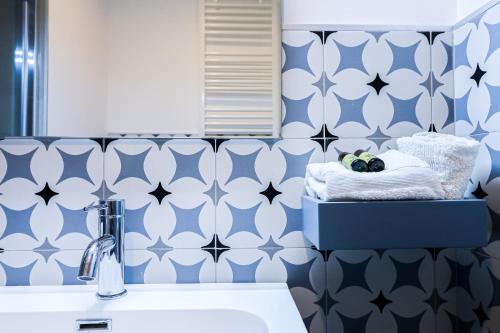 a bathroom with blue and white wallpaper and a sink at Umberto I by Casa di Marco in Sannicola