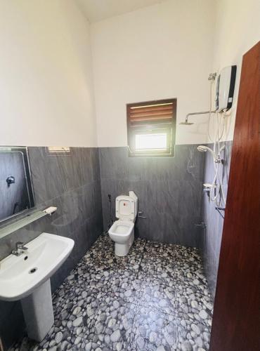a bathroom with a toilet and a sink at Hiru Villa in Bentota