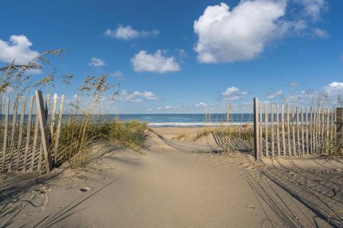 a sandy beach with a fence and the ocean at 4785 - Paradise Found in Kitty Hawk