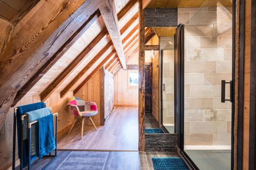 an attic hallway with a red chair in a room at Chalet Liloo sous la neige in Saint-Sorlin-dʼArves