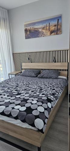 a bedroom with a bed with a black and white comforter at Aprum Apartments 10C in Pobierowo