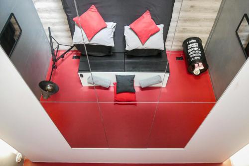 a room with a red table with pillows on it at Suite CinéRoom à 25 min de Paris in Franconville