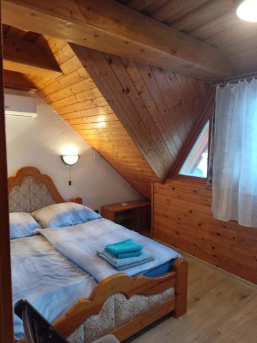 a bedroom with a bed in a wooden attic at Ferienhaus Magyar in Lovas