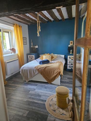 a bedroom with a bed and a blue wall at Maison du bonheur in Seur