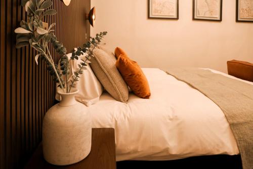 a bedroom with a white vase with flowers in it at Lovely Studio Flat on Bath Road - Flat 2 in Bristol