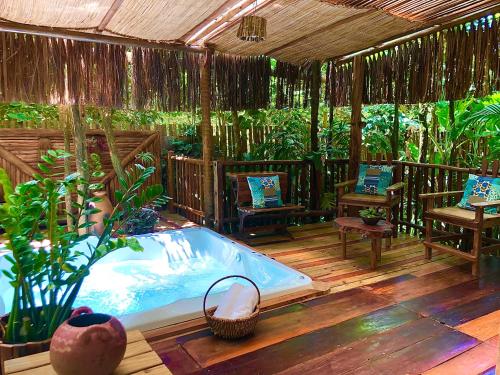 a jacuzzi tub on a deck in a garden at Bangalô Maria, luxo próximo ao mar in Trancoso