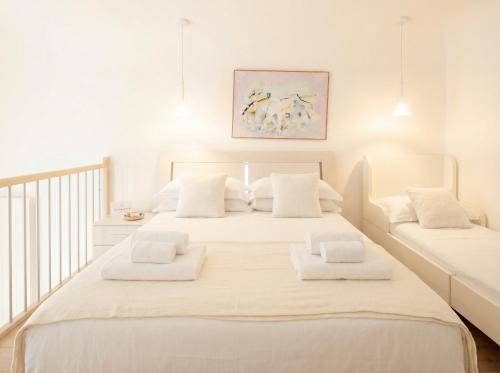 a white bedroom with a large bed with white pillows at Lemon Tree House in Bari