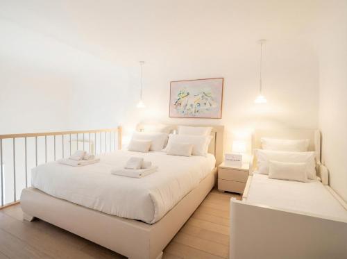 a white bedroom with two beds with white pillows at Lemon Tree House in Bari