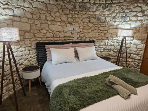 a bedroom with a bed with a stone wall at Le Moulin de la Motte Baudoin in Noyers-sur-Cher