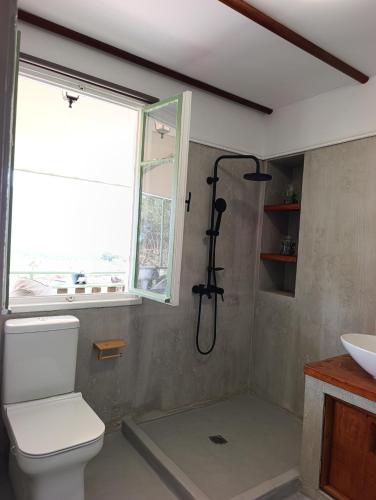 ein Badezimmer mit Dusche, Toilette und Fenster in der Unterkunft Linos Cottage in Pouláta