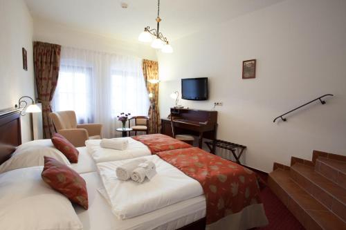 a hotel room with two beds and a television at Hotel Joseph 1699 in Třebíč