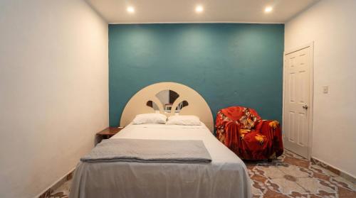 a bedroom with a bed and a blue wall at Hotel&Hostal Trinidad in La Ceiba