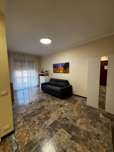 a living room with a black couch in a room at Grazioso Appartamento Ostia Roma in Lido di Ostia