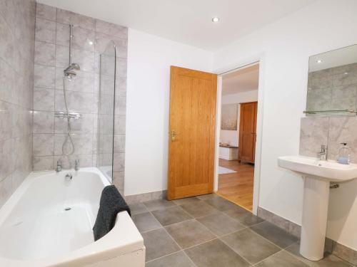 a bathroom with a tub and a sink at Bluebell Cottage in Maidstone
