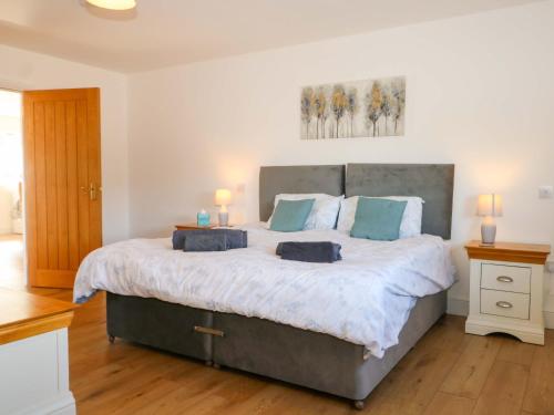 a bedroom with a large bed with blue pillows at Bluebell Cottage in Maidstone