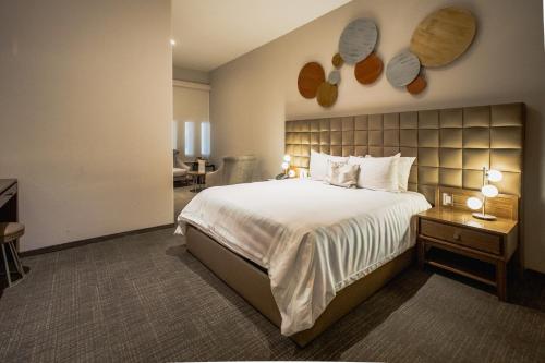 a bedroom with a large white bed and a desk at Antigua Hotel Boutique in Mexico City