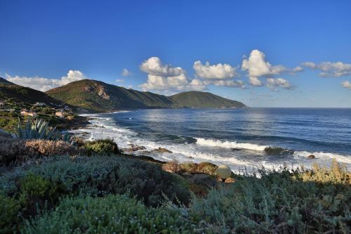 a view of the ocean with mountains in the background at Village de vacances Paese di Lava, Grand Ajaccio in Alata