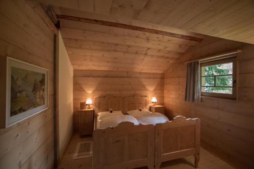 a bedroom with two beds in a log cabin at Berghütte Sommerstall in Redagno