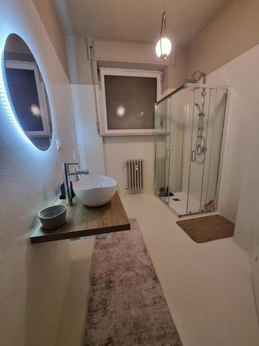 a bathroom with a sink and a glass shower at TM My Home in Novara