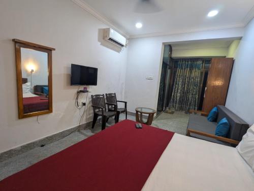 a bedroom with a bed and a tv and a couch at Pavitra Beach Home in Baga