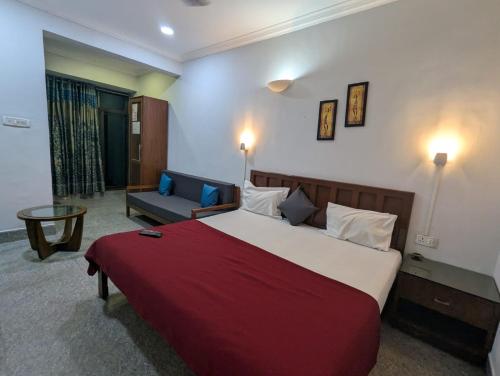 a hotel room with a large bed and a couch at Pavitra Beach Home in Baga