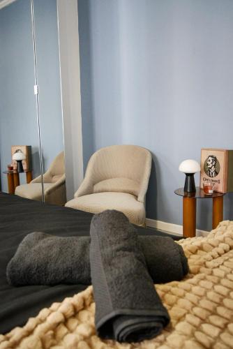 a bedroom with a chair and a bed with a blanket at Chocolat Paris, Cozy apartment in Levallois-Perret