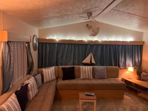 a living room with a couch and a table at Coastal Beachfront Caravan in Brightlingsea