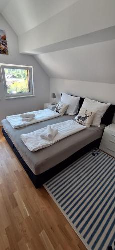 a bedroom with two beds and a window at Penthouse Vero I Bergblick I Seenähe I Hallstatt in Obertraun