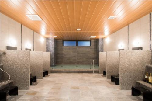 a room with a row of stalls in a building at Sun Hotel Kudamatsu in Hanaoka