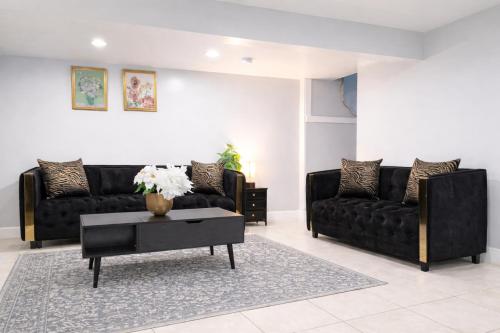 a living room with two black couches and a table at Modern Newark 1BR Apartment, Near Penn Station and EWR in Newark