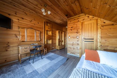 a bedroom in a log cabin with a bed and a desk at Chata u Szymczaka in Łopuszna
