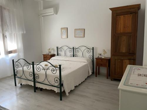 a bedroom with a bed and a wooden cabinet at Andrea E Valentina in S'archittu Cuglieri