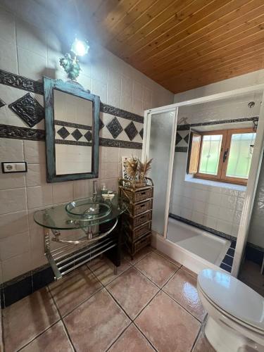 a bathroom with a glass sink and a shower at Casa del arco in Tarilonte