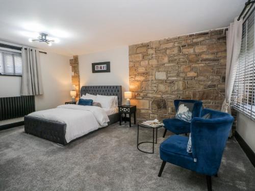 a bedroom with a bed and a stone wall at 2 Manorhouse Farm in Rochdale