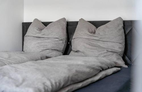 a bed with two pillows on top of it at Dom Central Suite in Greifswald