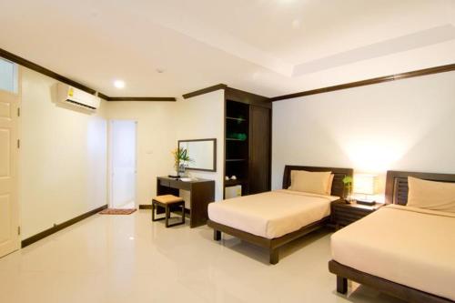 a bedroom with two beds and a desk and a bed sidx sidx sidx at Makathanee Resort in Ko Mak