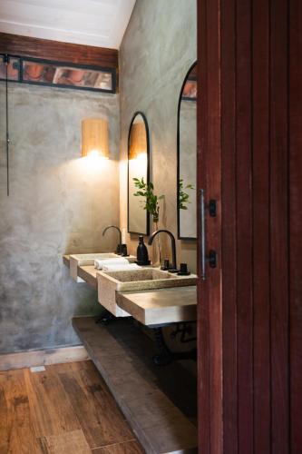 a bathroom with two sinks and two mirrors at Brisa da Serra Pousada Boutique in Tiradentes