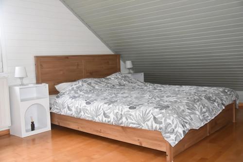 a bedroom with a bed with a gray and white comforter at La petite maison en Ardenne in Marche-en-Famenne