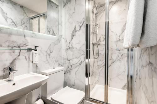 a bathroom with a shower and a toilet and a sink at STG Hotel Oxford Street - formerly St Giles London Hotel in London