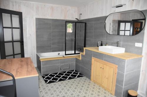 a bathroom with a sink and a mirror at La petite maison en Ardenne in Marche-en-Famenne