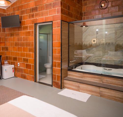a bathroom with a tub in a brick wall at Pousada Pitauá in Socorro