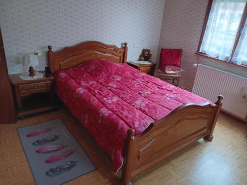 a bedroom with a large bed with a red comforter at Maison d hote avec diner in Sarralbe