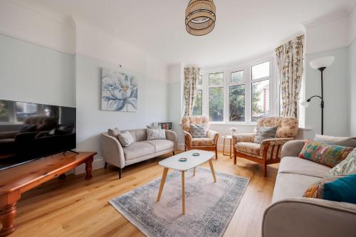 a living room with a couch and a table at Primrose - Refurbished Family Home, With Rear Garden in Poole