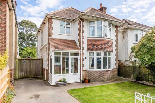 a brick house with white doors and a fence at Primrose - Refurbished Family Home, With Rear Garden in Poole