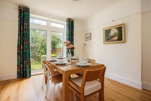 a dining room with a wooden table and chairs at Primrose - Refurbished Family Home, With Rear Garden in Poole
