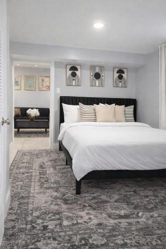 a bedroom with a large white bed and a couch at Modern Newark 1BR Apartment, Near Penn Station and EWR in Newark